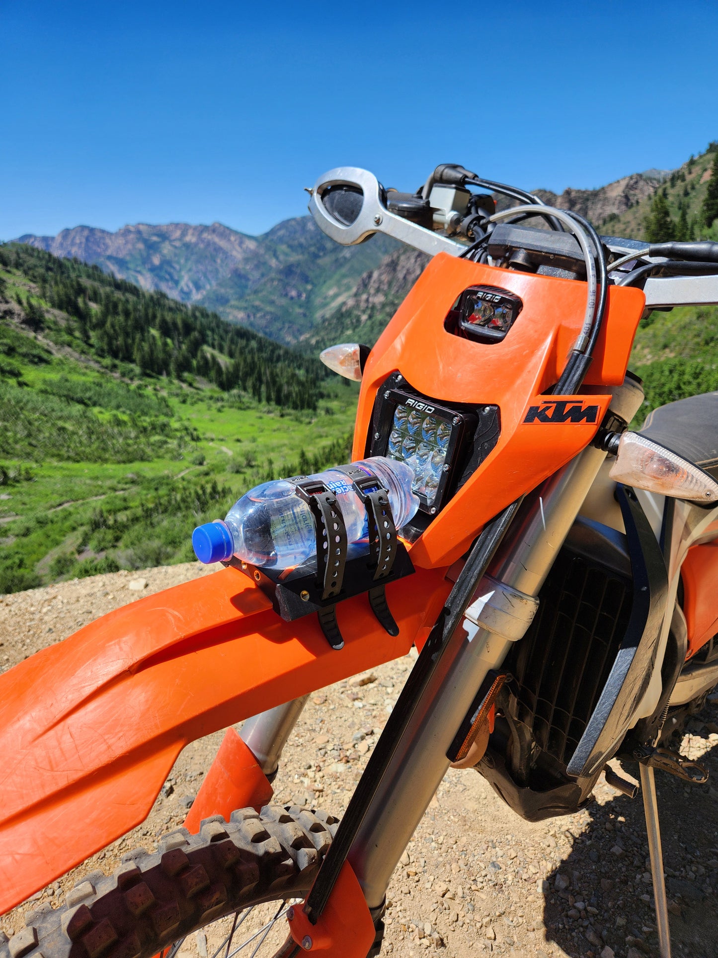 KTM dirt bike with versatile front fender rack, featuring orange anti-slip silicone inserts and threaded brass mounts for secure gear storage.