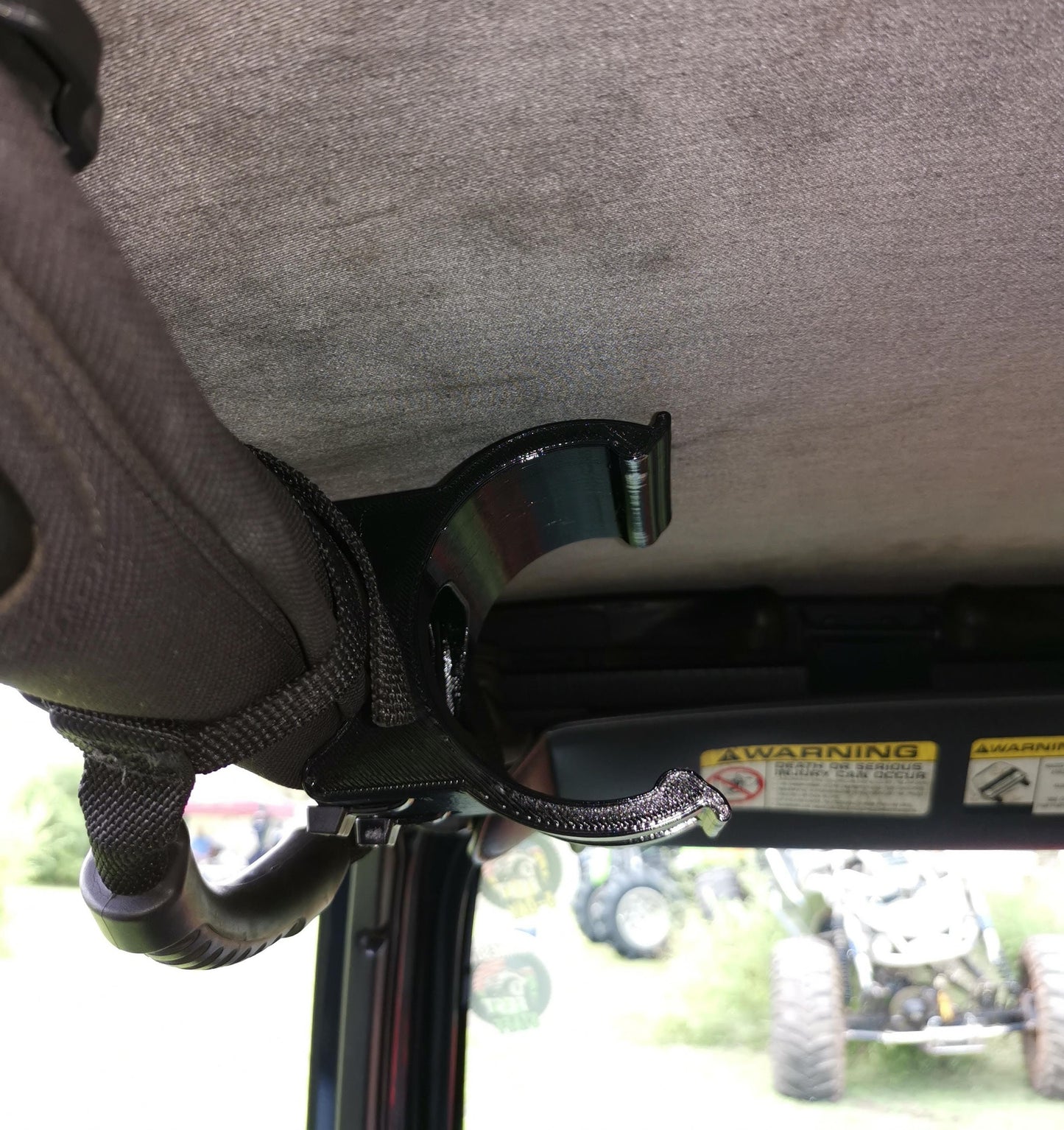 Empty roll bar water bottle holder in a Jeep TJ, positioned close to the soft top for maximum headroom.