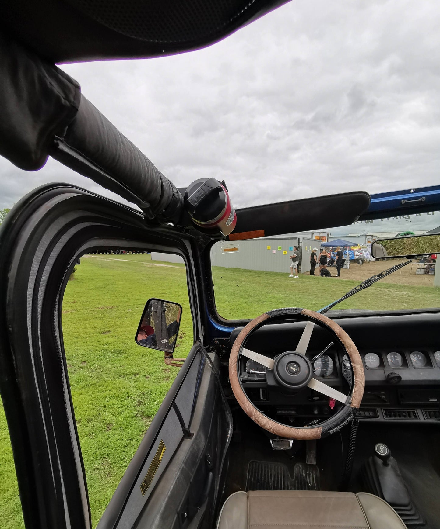 Jeep YJ water bottle holder mounted to the roll bar, showing a secure fit and ideal placement for off-road adventures at outdoor events.