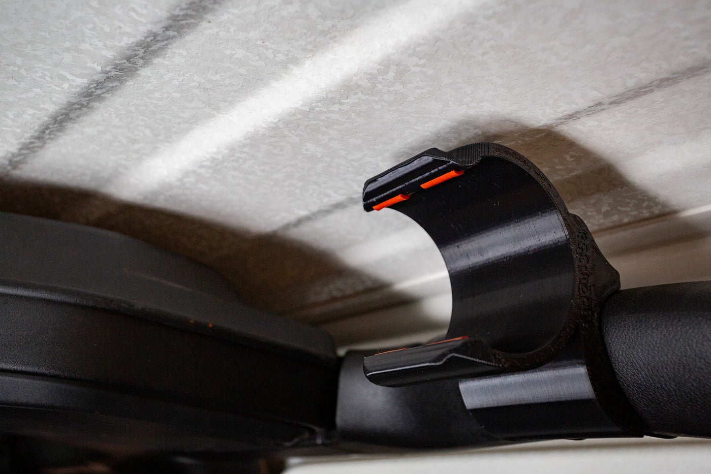 Jeep JL water bottle holder with orange silicone inserts, securely mounted on roll bar, perfectly fitting contours for off-road use.