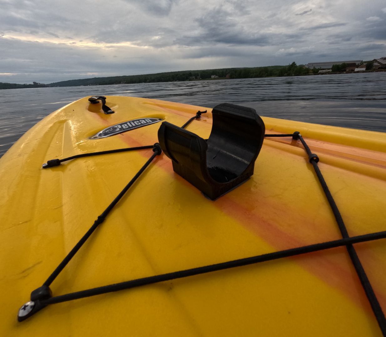 Detail shot of paddleboard water bottle holder installed on board, highlighting durable design and lake scenery, perfect for paddleboarding enthusiasts