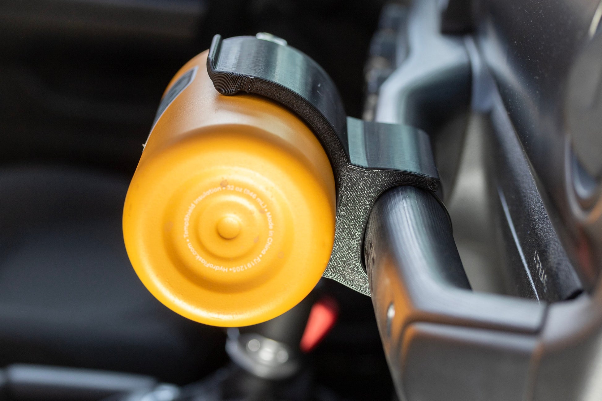 Close-up side view of Water Bottle Holder for Jeep JL securely mounted to grab handle, showcasing precise fit and seamless integration