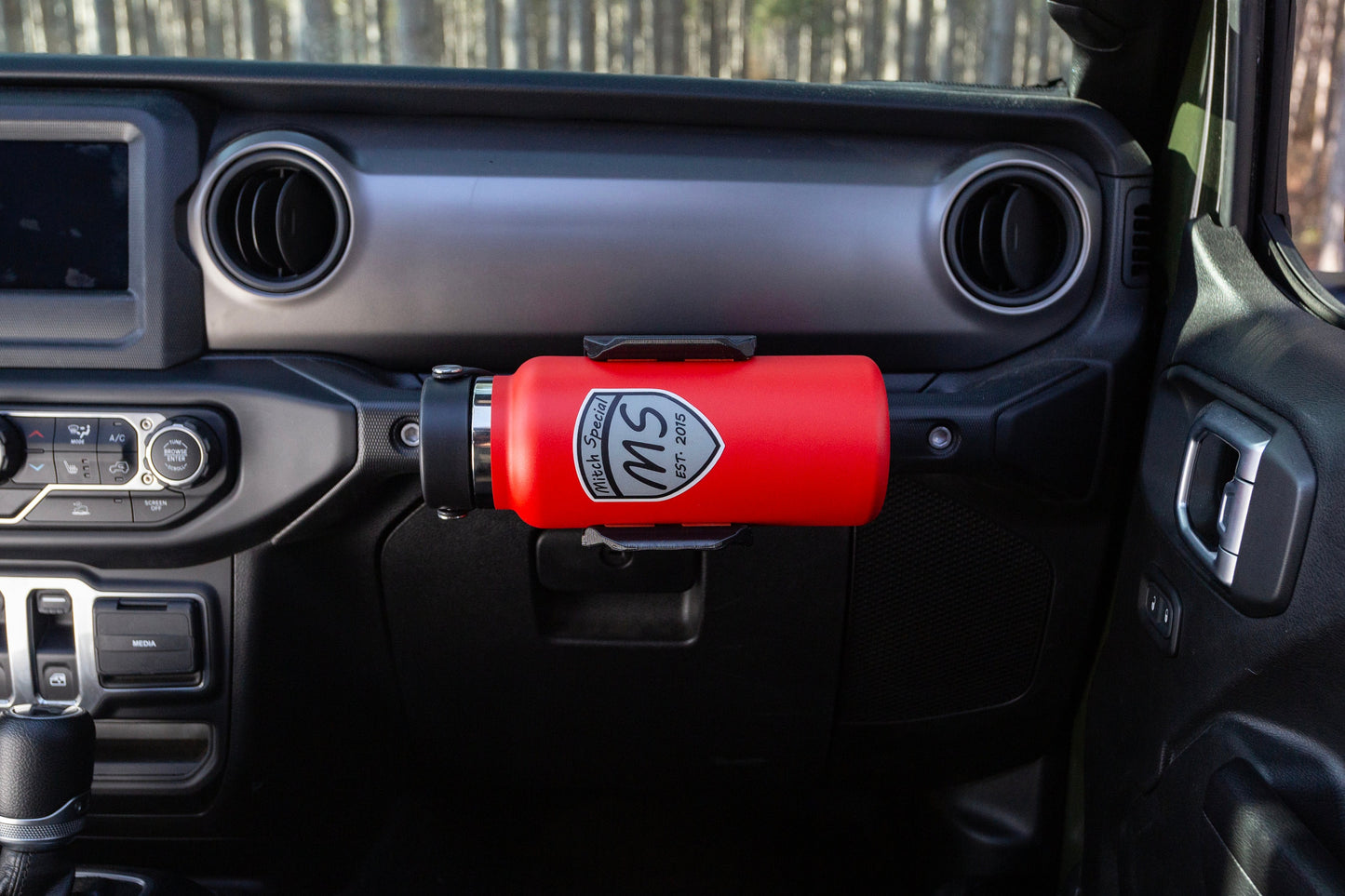 Passenger seat perspective of Jeep JL water bottle holder mounted to grab handle, demonstrating its convenient location and easy access to water bottle