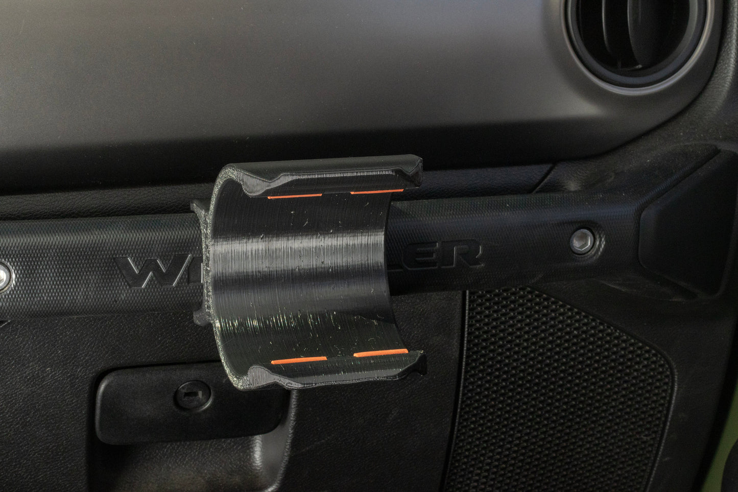 Angled view of Heavy-Duty Water Bottle Holder for Jeep JL mounted to grab handle, showcasing empty holder with orange silicone inserts for secure bottle grip