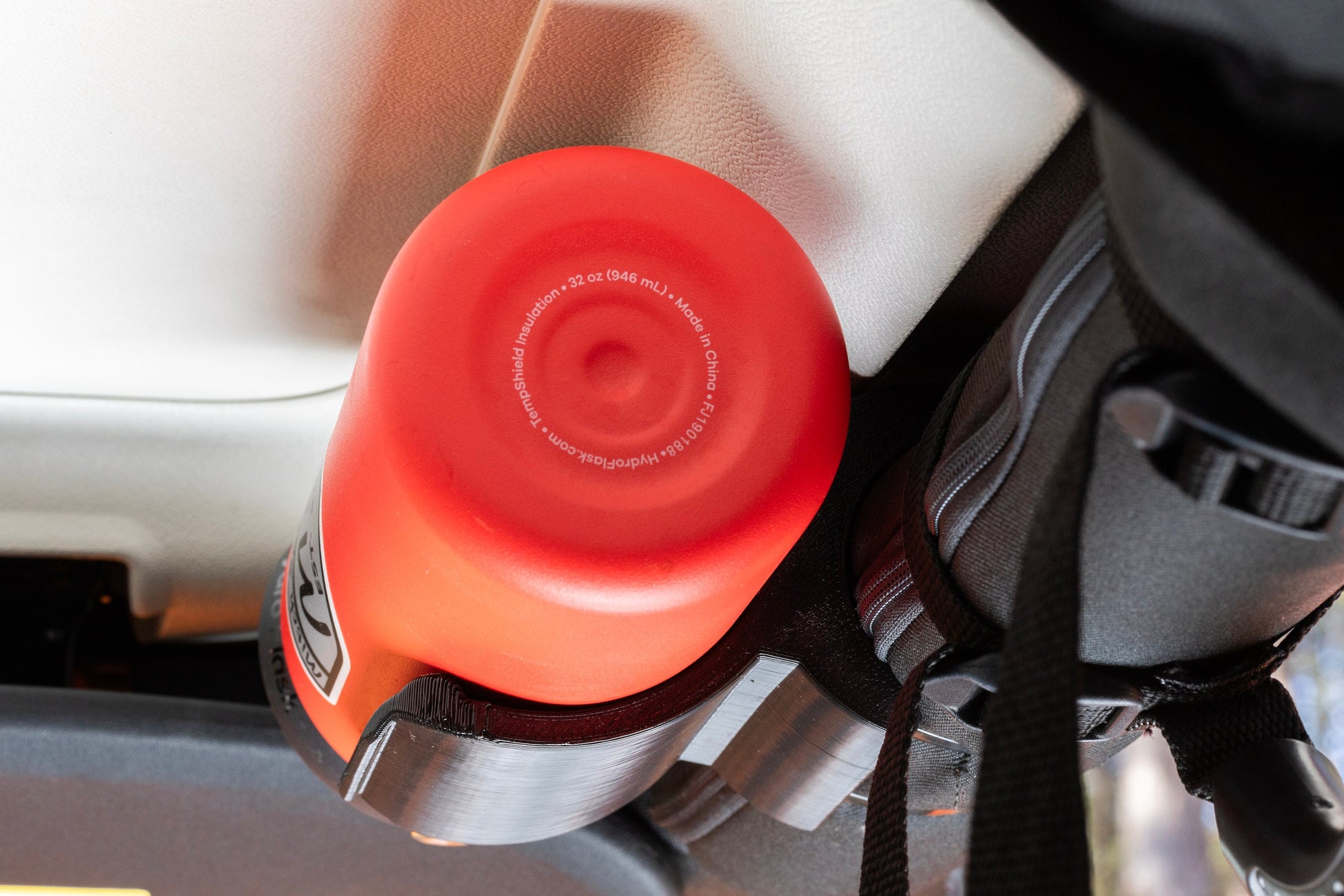 Rear view of water bottle holder mounted to Jeep JK roll bar, showcasing sleek design with bottle tucked closely to roof, maximizing interior space.