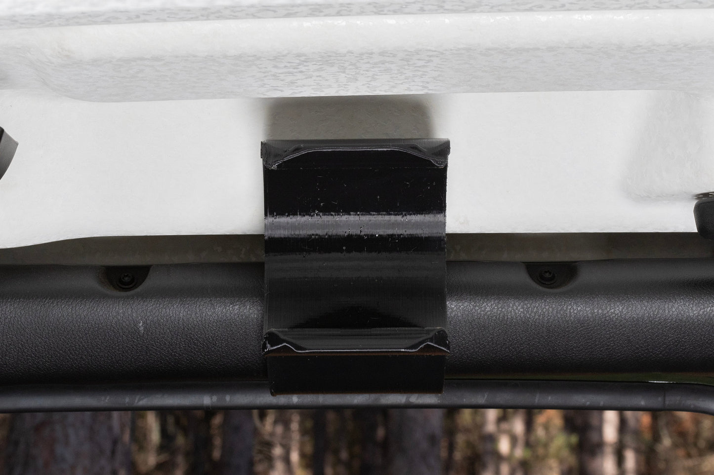 Close-up image of an empty water bottle holder mounted to the front roll bar of a Jeep JL, highlighting its slim profile and door clearance, ensuring effortless door opening and closing without obstruction.