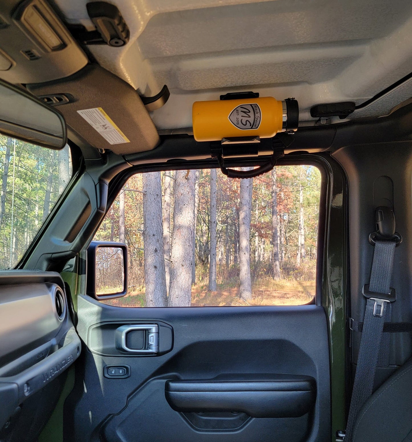 Image of a Jeep JL with a water bottle holder seamlessly mounted to the front roll bar, showcasing its integrated design and clearance from the passenger door, providing a convenient and accessible storage solution for off-road adventures.