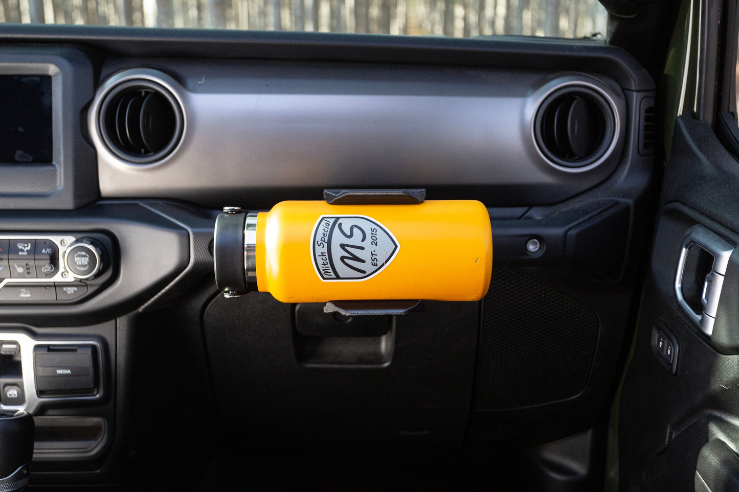 Passenger seat perspective of Jeep JL water bottle holder mounted to grab handle, demonstrating its convenient location and easy access to water bottle