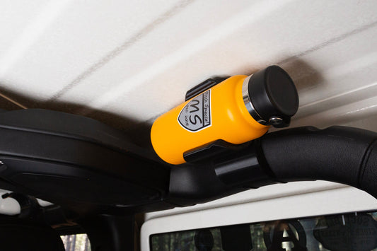 Image of Jeep JL rear roll cage water bottle holder, viewed from a slight downward angle, showcasing its elevated and secure position, keeping the bottle up and out of the way while maintaining easy access.